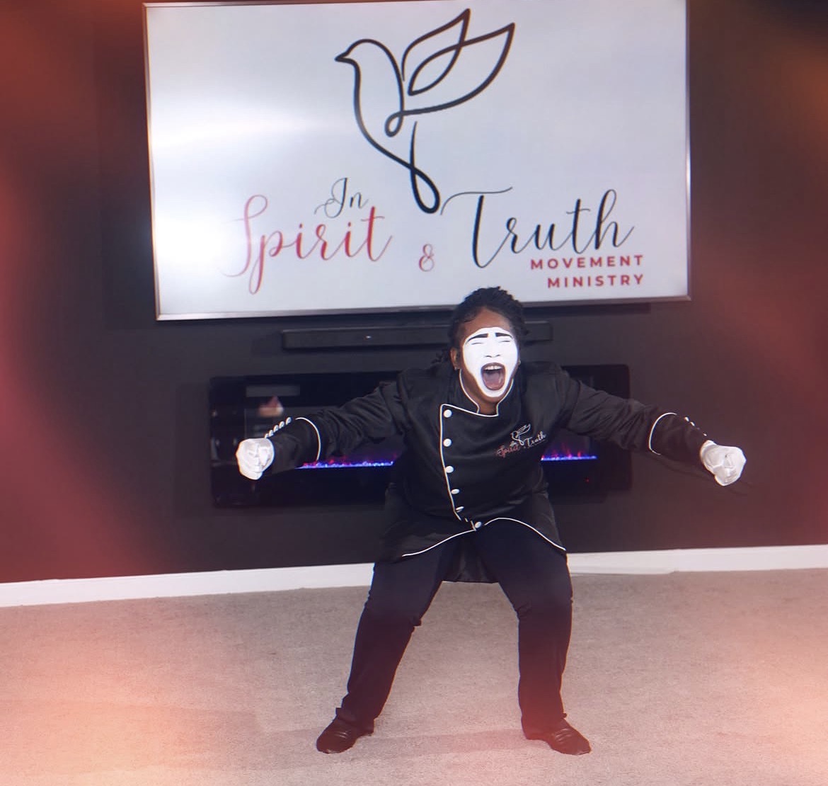 Altranette Love-Gregory in full mime makeup ministering in front of the Spirit & Truth logo